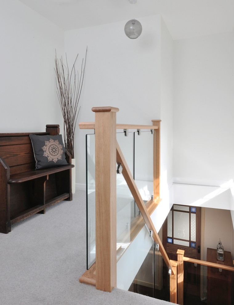 Réalisation d'un escalier design en L de taille moyenne avec des marches en bois, des contremarches en verre et un garde-corps en bois.