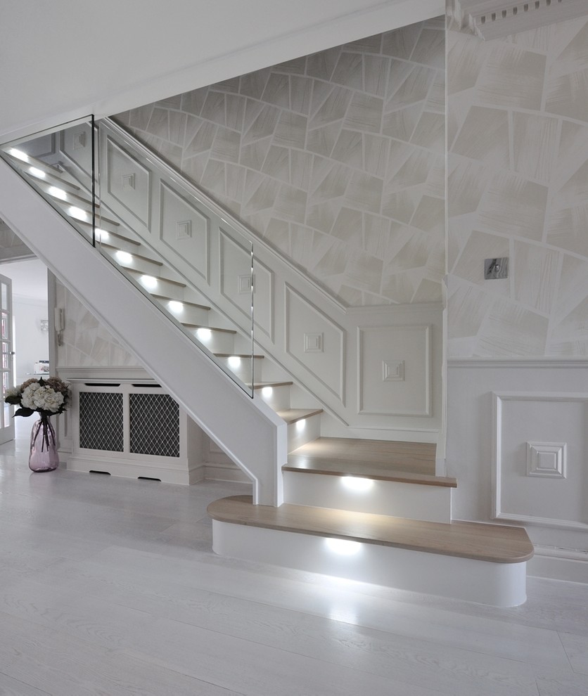 Exemple d'un grand escalier courbe tendance avec des marches en bois, des contremarches en verre et un garde-corps en verre.