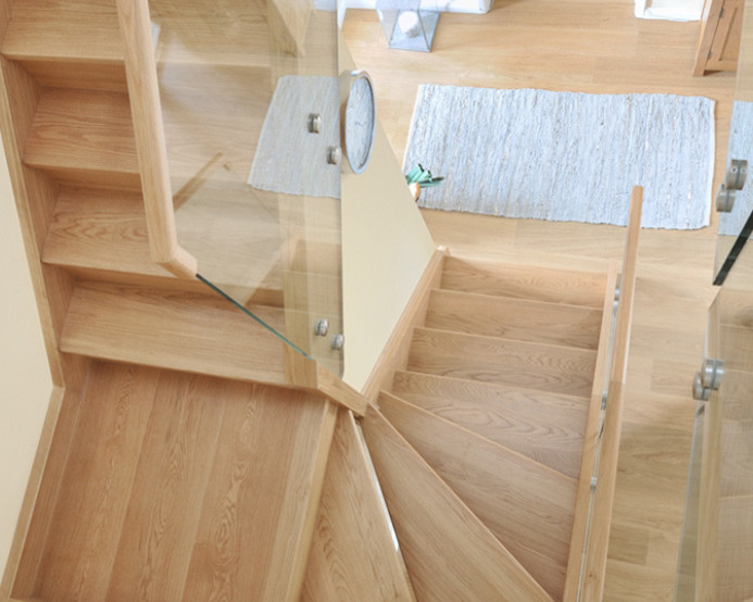 カーディフにある中くらいなコンテンポラリースタイルのおしゃれな折り返し階段 (木材の手すり、木の蹴込み板) の写真