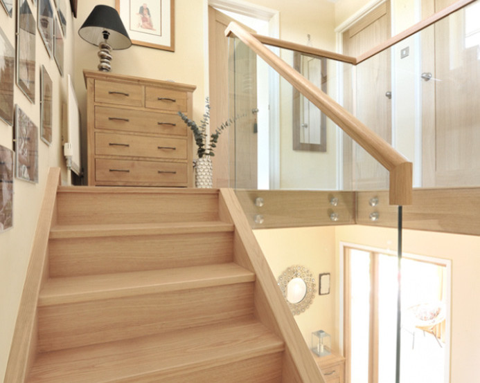 Idées déco pour un escalier contemporain en U de taille moyenne avec des marches en bois, des contremarches en verre et un garde-corps en bois.
