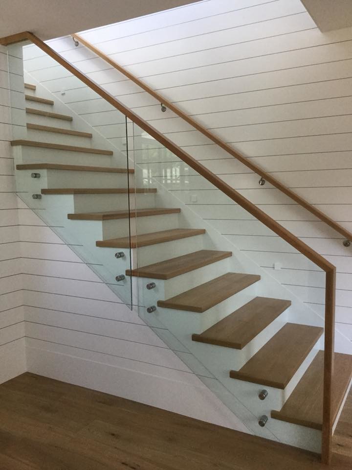 バンクーバーにある中くらいなコンテンポラリースタイルのおしゃれな直階段 (フローリングの蹴込み板、混合材の手すり) の写真