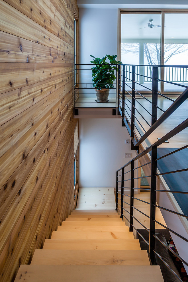 Photo of a medium sized contemporary wood straight staircase in New York with open risers.