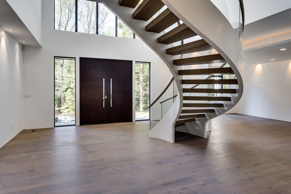 Стильный дизайн: лестница на больцах в современном стиле с деревянными ступенями и стеклянными перилами без подступенок - последний тренд
