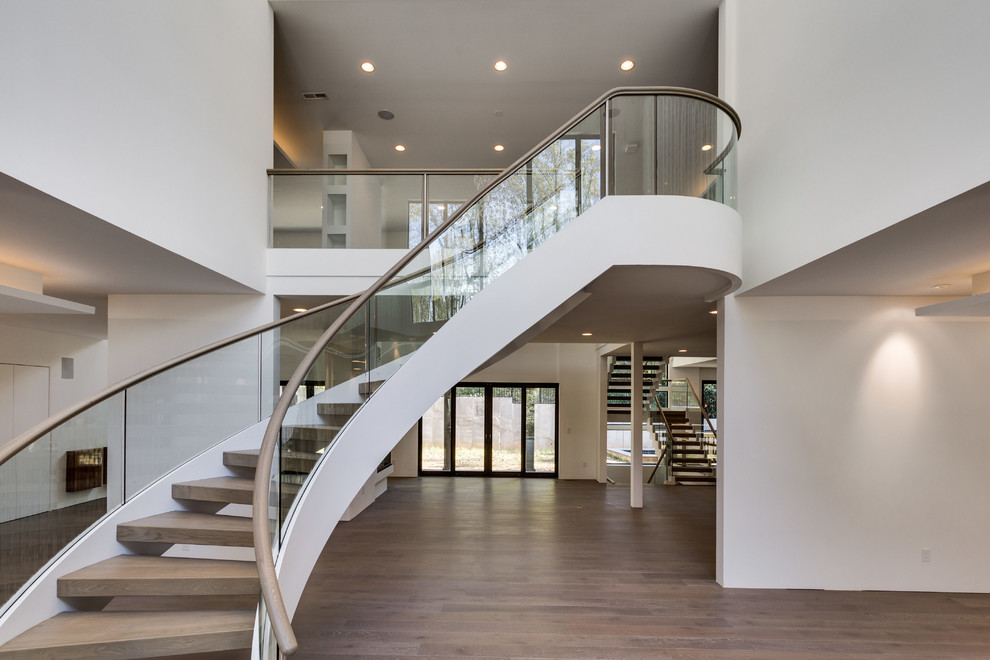 Imagen de escalera suspendida contemporánea sin contrahuella con escalones de madera y barandilla de vidrio