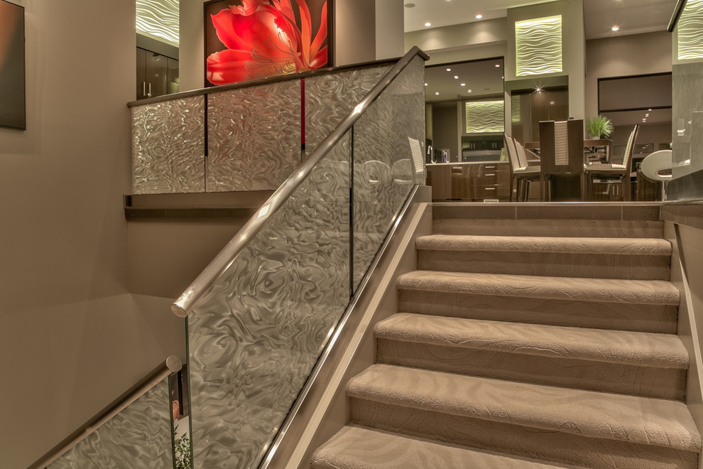 Example of a large trendy carpeted u-shaped glass railing staircase design in Omaha with carpeted risers