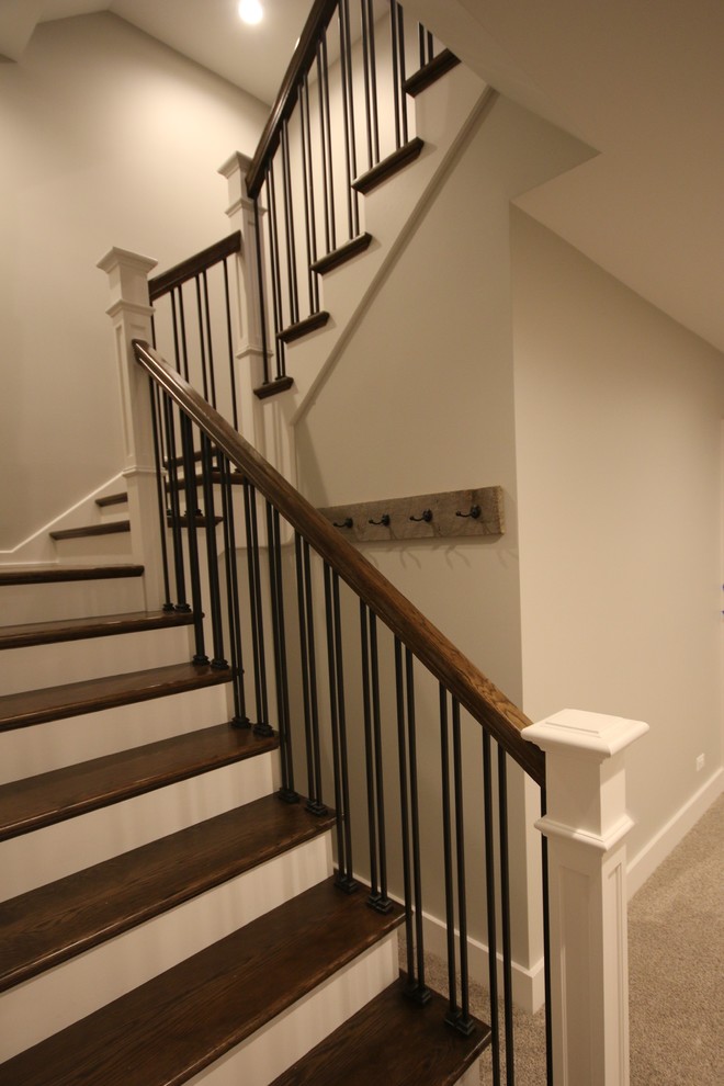 Imagen de escalera en U urbana grande con escalones de madera, contrahuellas de madera pintada y barandilla de metal