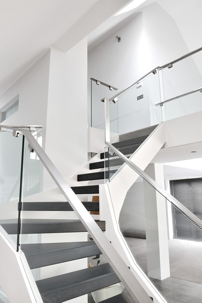 Diseño de escalera en L contemporánea de tamaño medio con escalones de madera, contrahuellas de metal y barandilla de metal
