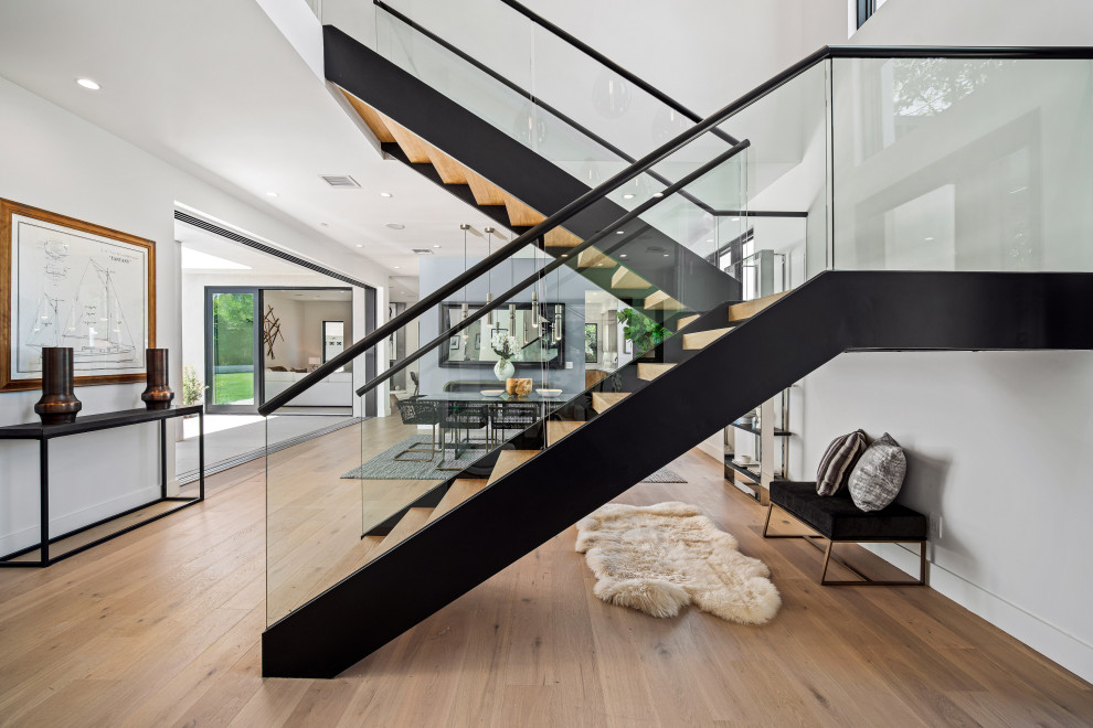 Источник вдохновения для домашнего уюта: п-образная лестница в современном стиле с деревянными ступенями и стеклянными перилами без подступенок