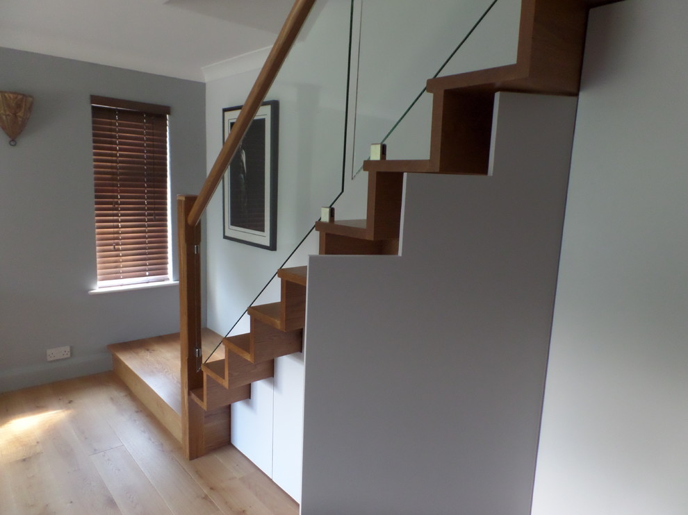 Mid-sized trendy wooden l-shaped staircase photo in London with wooden risers