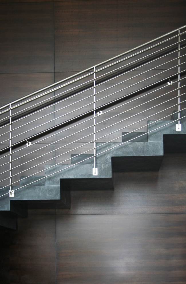 Large contemporary concrete l-shaped wire cable railing staircase in San Diego with concrete risers.