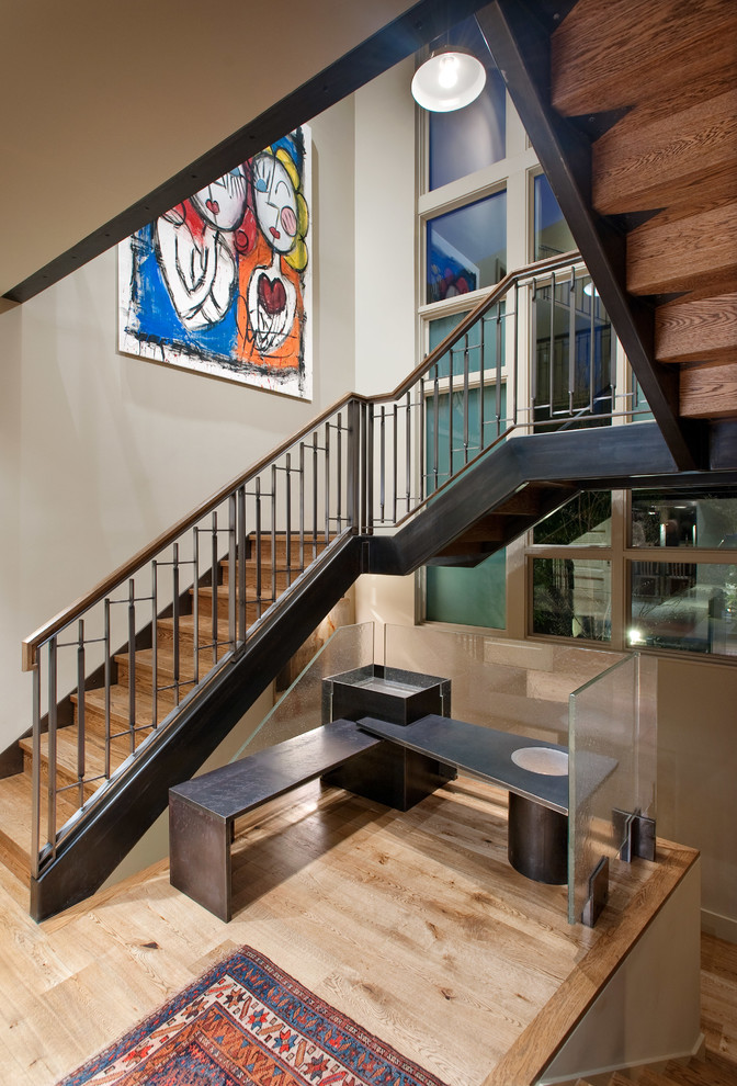 Réalisation d'un escalier design avec des contremarches en bois, des marches en bois et un garde-corps en métal.
