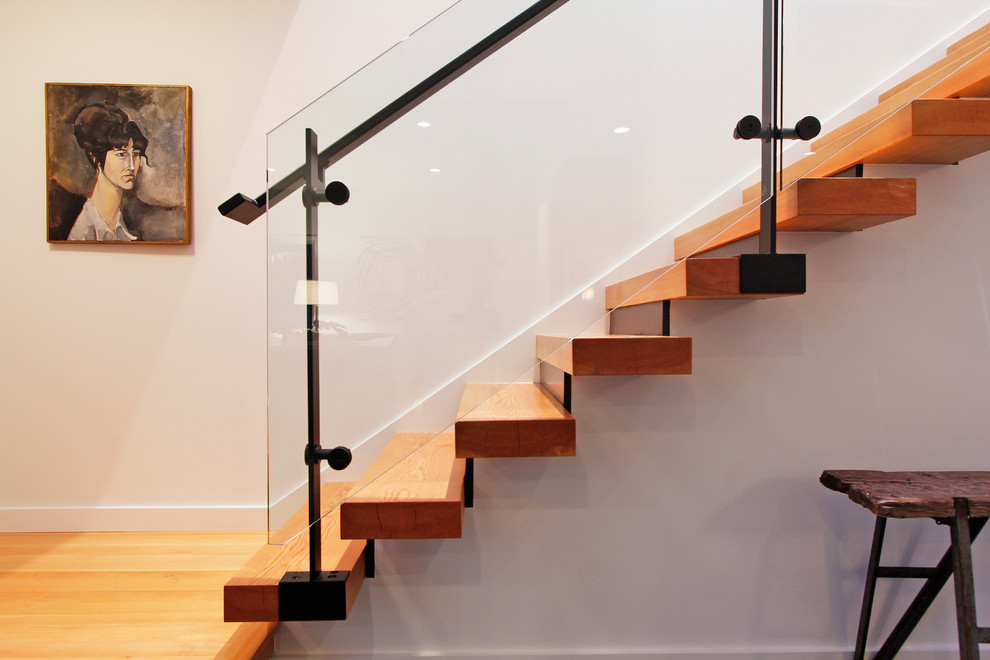 Exemple d'un escalier droit tendance avec un garde-corps en verre.