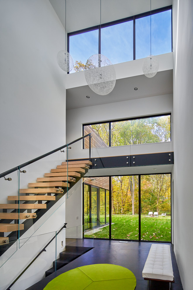 Inspiration for a contemporary wood straight glass railing staircase in Other with open risers.