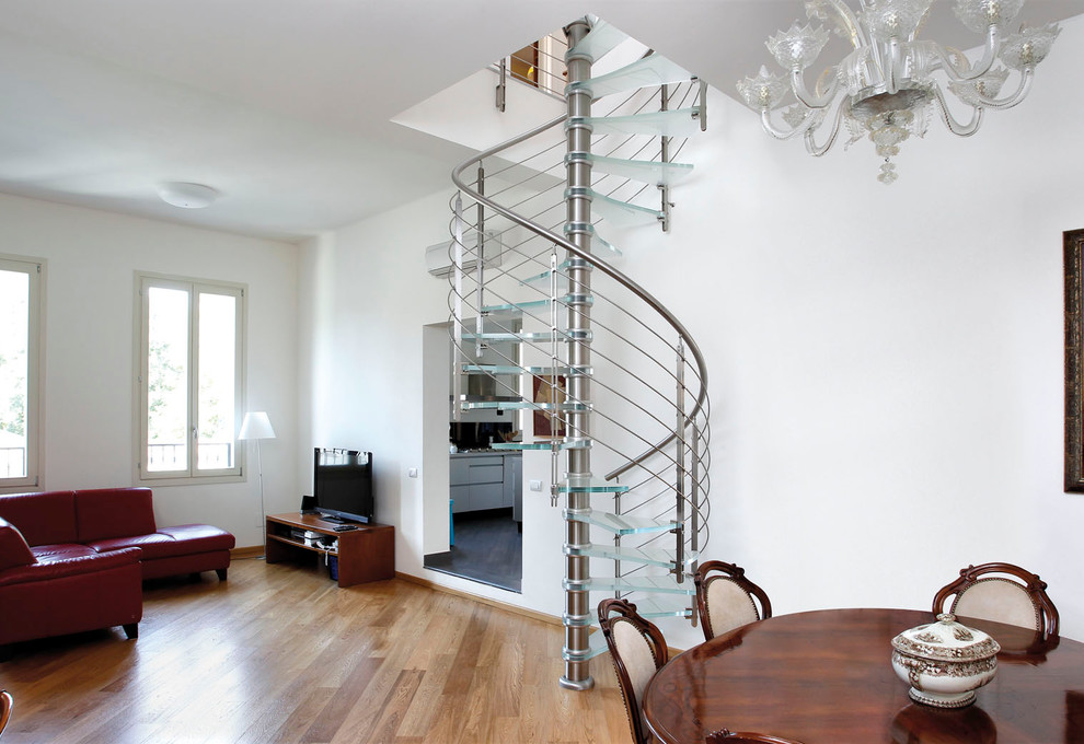 Réalisation d'un escalier sans contremarche hélicoïdal design avec des marches en verre, un garde-corps en câble et éclairage.