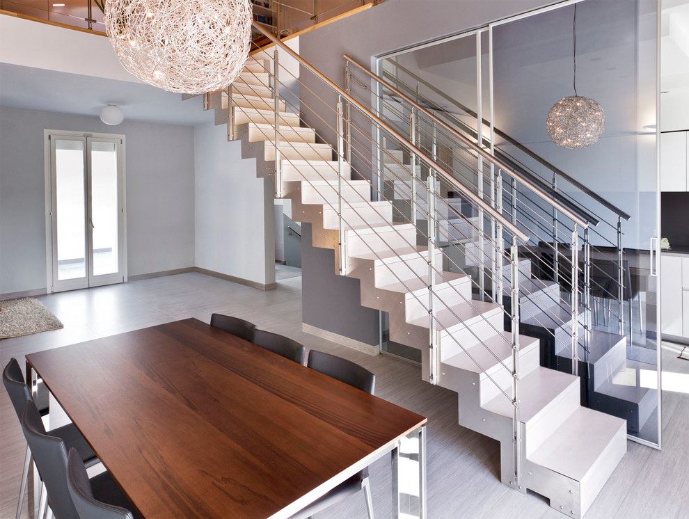 Стильный дизайн: прямая металлическая лестница в современном стиле с перилами из тросов и металлическими ступенями - последний тренд
