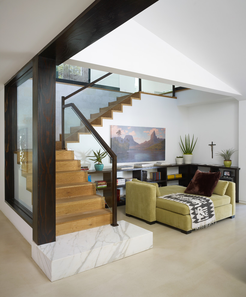 Ejemplo de escalera en L actual con escalones de madera, contrahuellas de madera y barandilla de vidrio