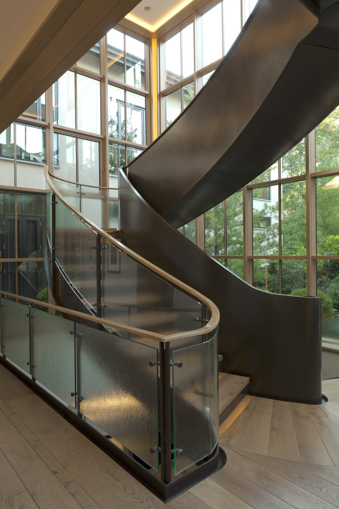 Cette image montre un escalier courbe design avec des marches en bois.