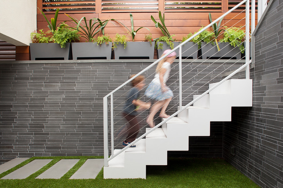Example of a trendy metal cable railing staircase design in San Francisco with metal risers