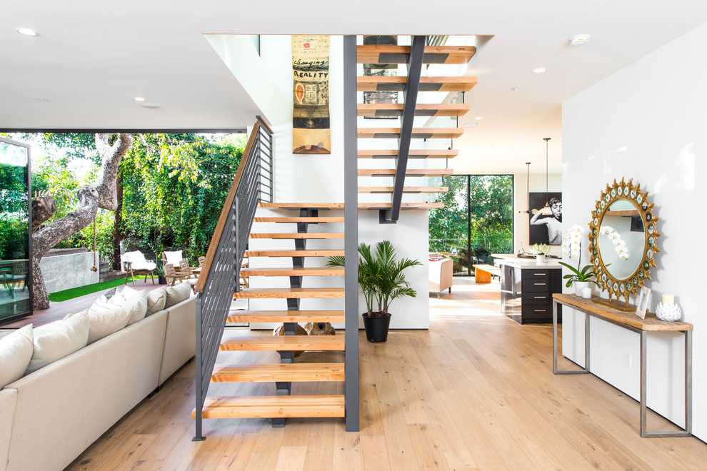 Ejemplo de escalera en U contemporánea sin contrahuella con escalones de madera y barandilla de metal