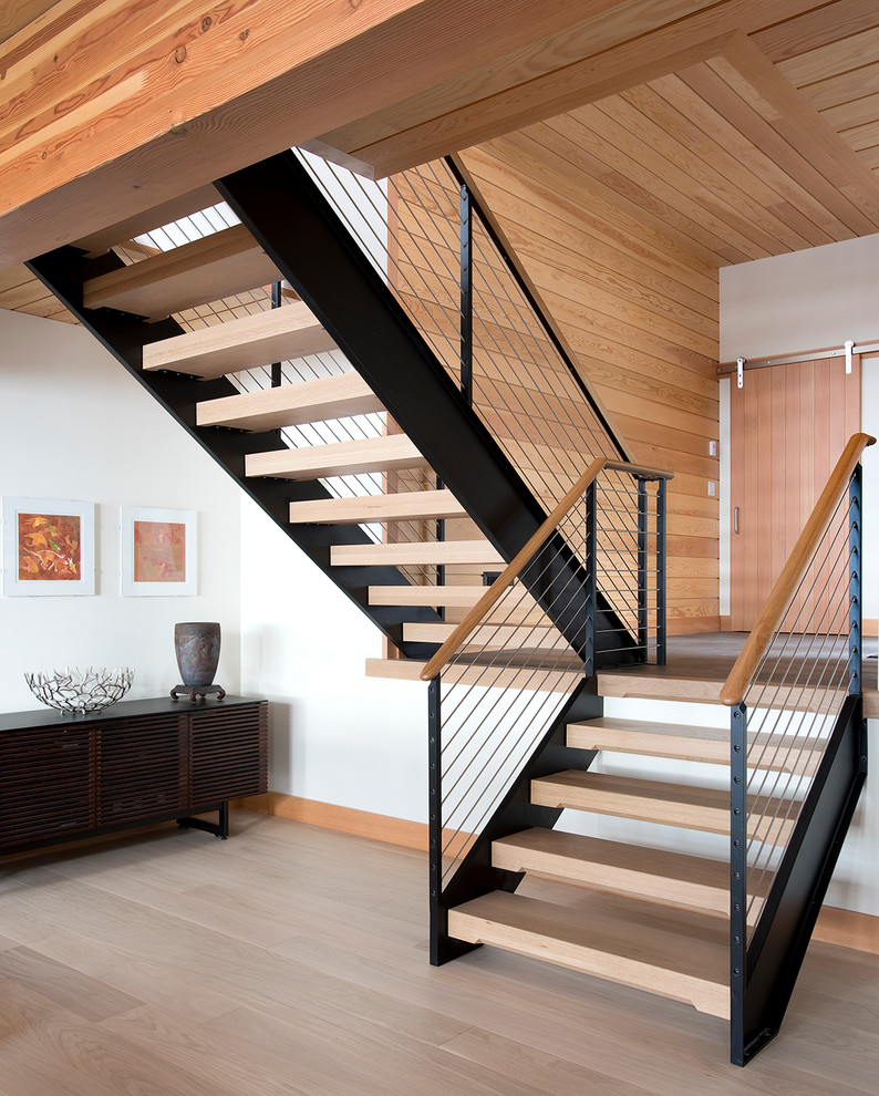Réalisation d'un escalier sans contremarche chalet en U de taille moyenne avec des marches en bois, un garde-corps en câble et palier.