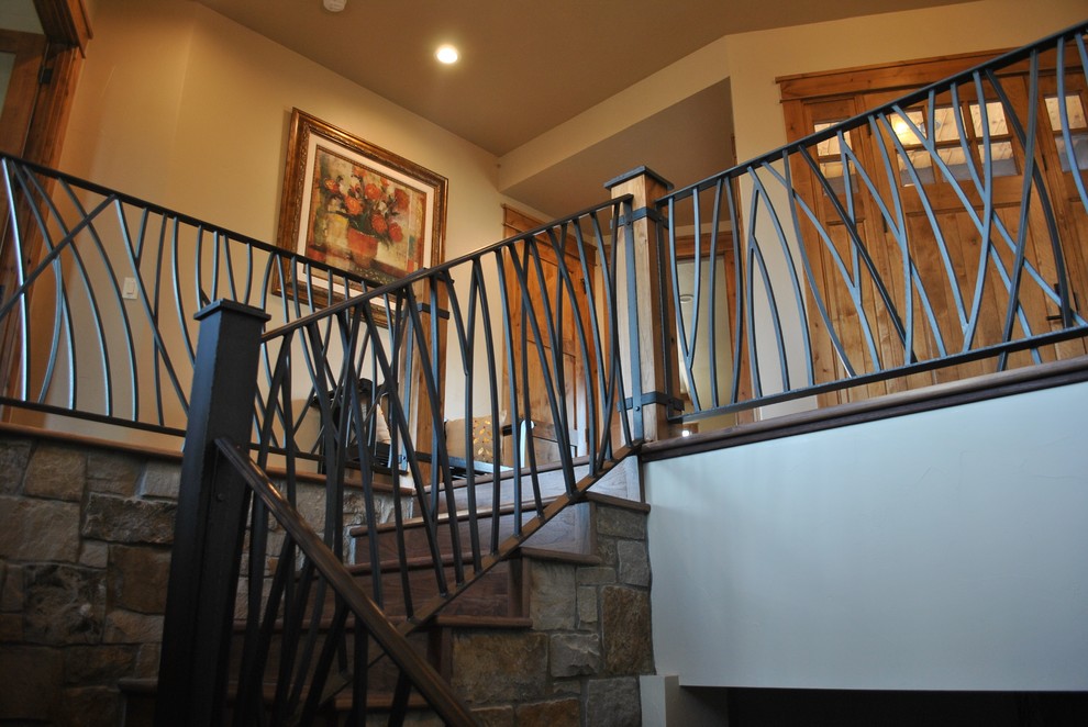 Idée de décoration pour un escalier chalet en L de taille moyenne avec des marches en bois, des contremarches en bois et un garde-corps en métal.