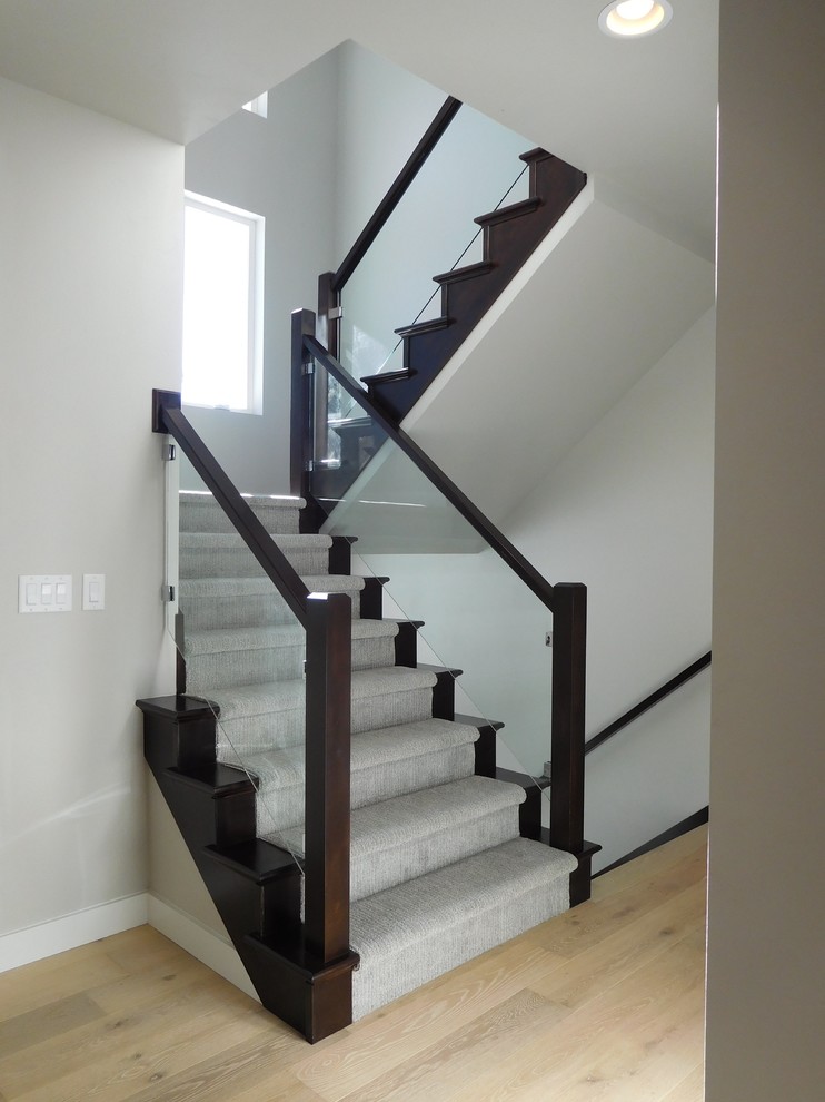 Aménagement d'un escalier classique en U de taille moyenne avec des marches en moquette, des contremarches en moquette et un garde-corps en bois.