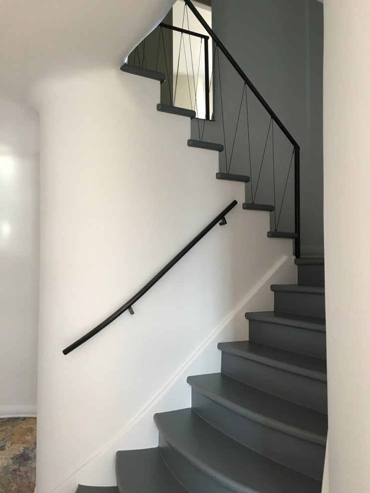 Modelo de escalera curva minimalista extra grande con escalones de metal y contrahuellas de madera