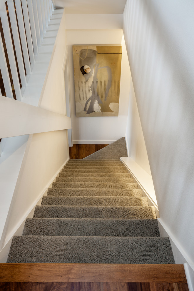 Diseño de escalera recta clásica de tamaño medio con escalones enmoquetados, contrahuellas enmoquetadas y barandilla de madera