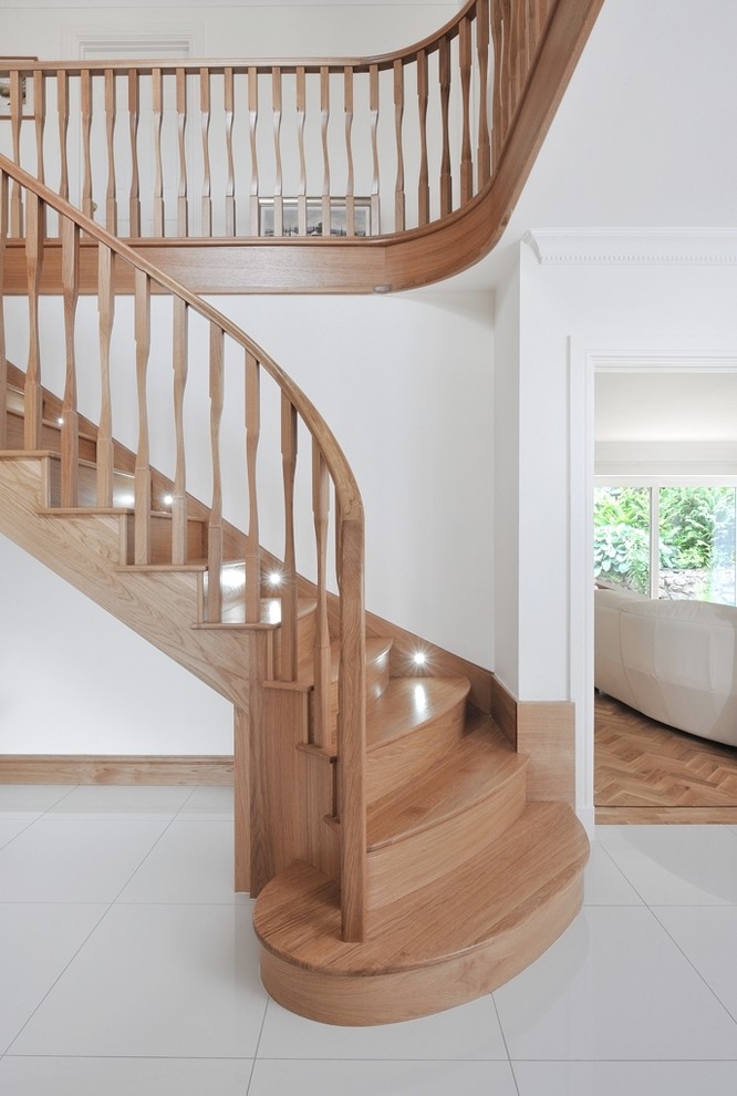 Photo of a large contemporary wood curved wood railing staircase in Other with wood risers.
