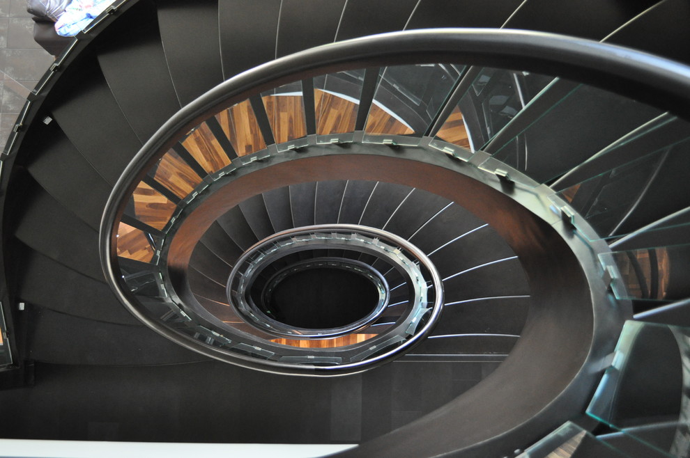 На фото: большая винтовая лестница в классическом стиле с крашенными деревянными ступенями без подступенок с