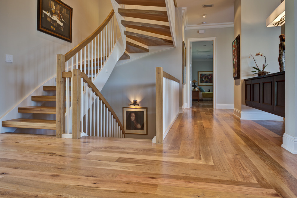 Example of a large transitional wooden curved open and wood railing staircase design in Miami