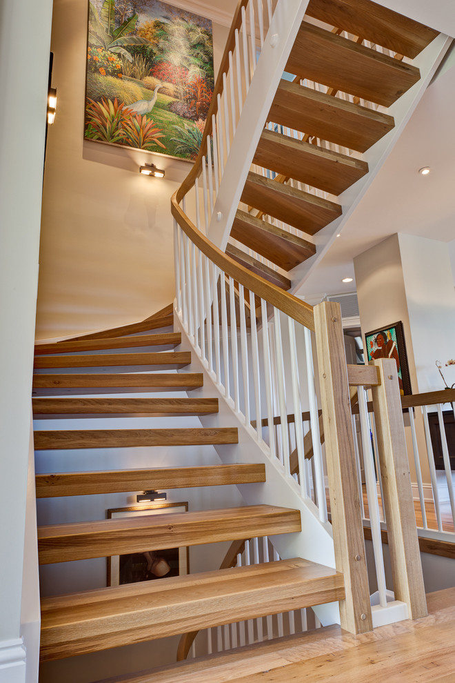 Aménagement d'un grand escalier sans contremarche courbe classique avec des marches en bois.