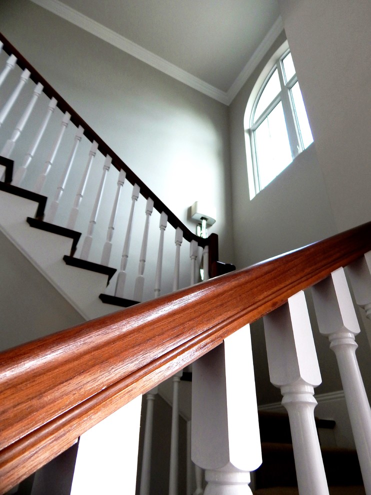 Aménagement d'un escalier classique avec des marches en bois, des contremarches en bois et un garde-corps en bois.