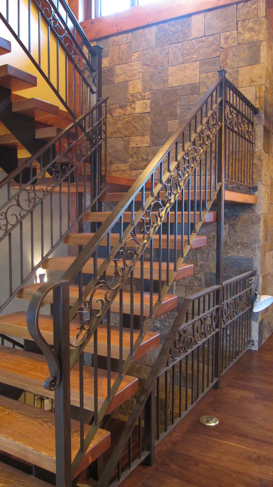 Idée de décoration pour un grand escalier sans contremarche droit chalet avec des marches en bois et un garde-corps en métal.