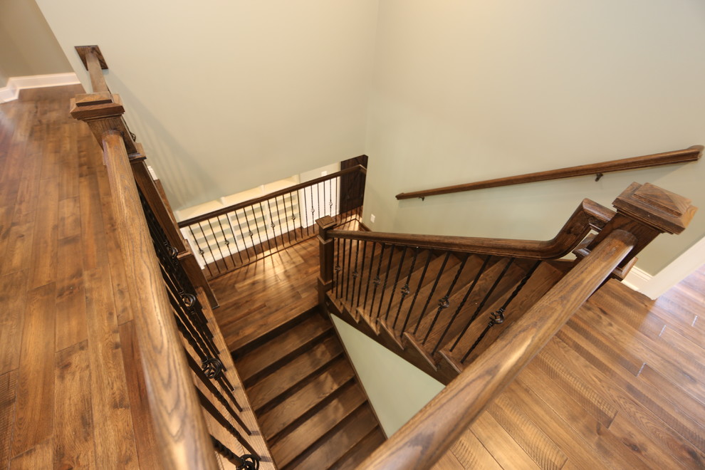 Large arts and crafts wooden u-shaped wood railing staircase photo in Chicago with wooden risers