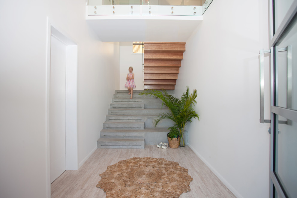 Imagen de escalera en U contemporánea de tamaño medio con escalones de hormigón, contrahuellas de madera y barandilla de vidrio