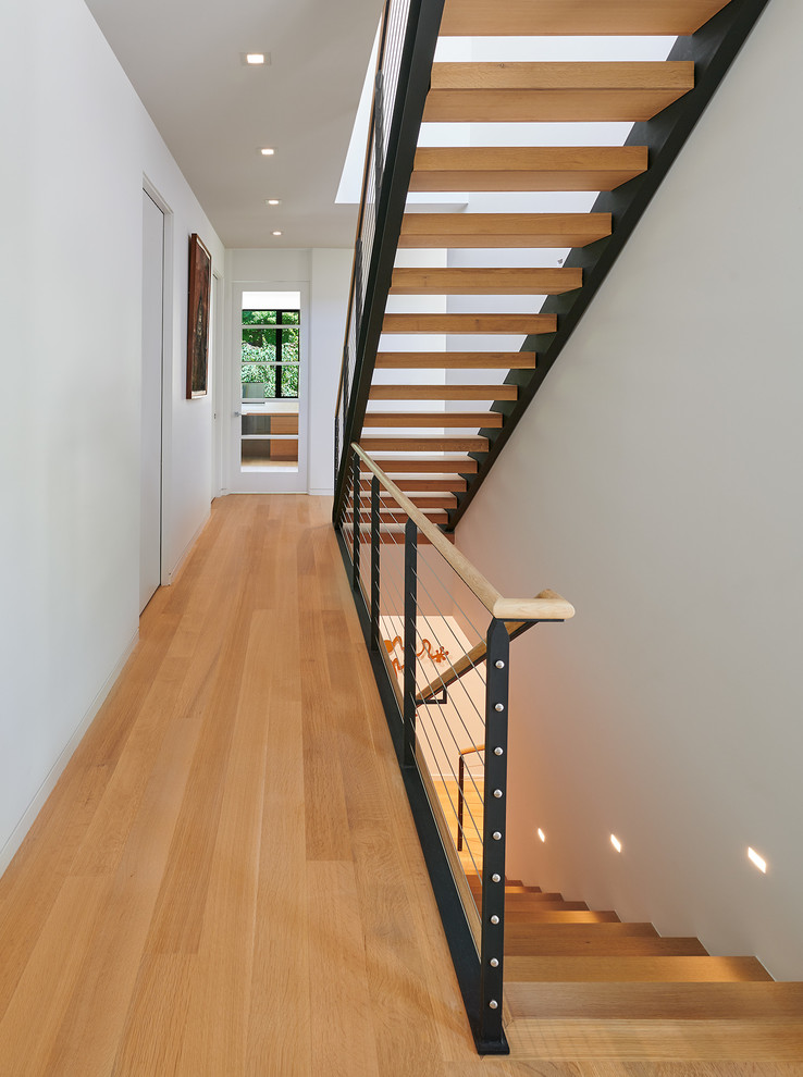 Exemple d'un grand escalier sans contremarche droit tendance avec des marches en bois et un garde-corps en câble.