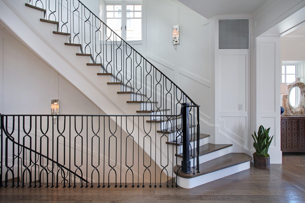 Staircase - large transitional wooden curved staircase idea in Orange County with painted risers