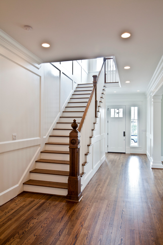 This is an example of a classic wood l-shaped staircase in Houston with wood risers and feature lighting.