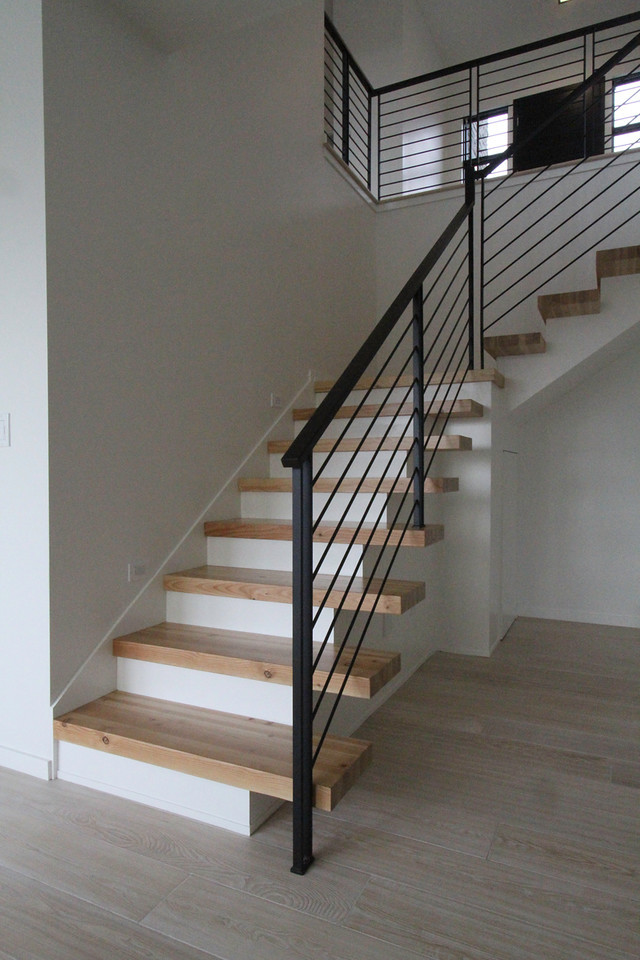 На фото: деревянная лестница на больцах, среднего размера в современном стиле с деревянными ступенями
