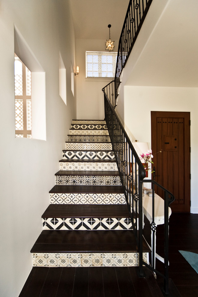 This is an example of a mediterranean wood metal railing staircase in Santa Barbara with tiled risers.