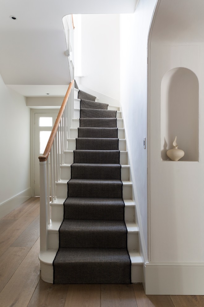 This is an example of a victorian painted wood l-shaped staircase in Oxfordshire with painted wood risers.