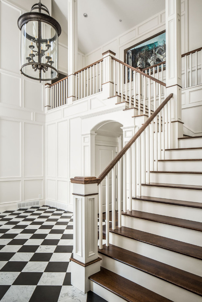 На фото: угловая лестница в классическом стиле с деревянными ступенями и крашенными деревянными подступенками