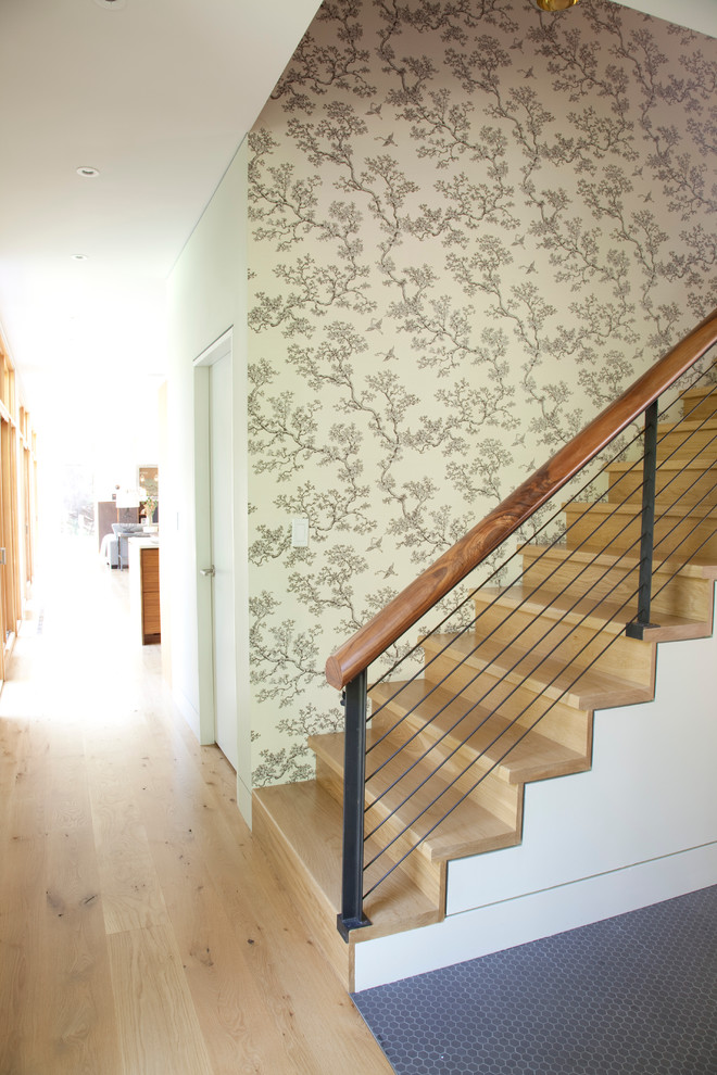 Trendy wooden cable railing staircase photo in New York with wooden risers
