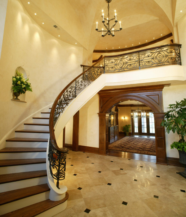 Large traditional wood curved staircase in Philadelphia with painted wood risers.