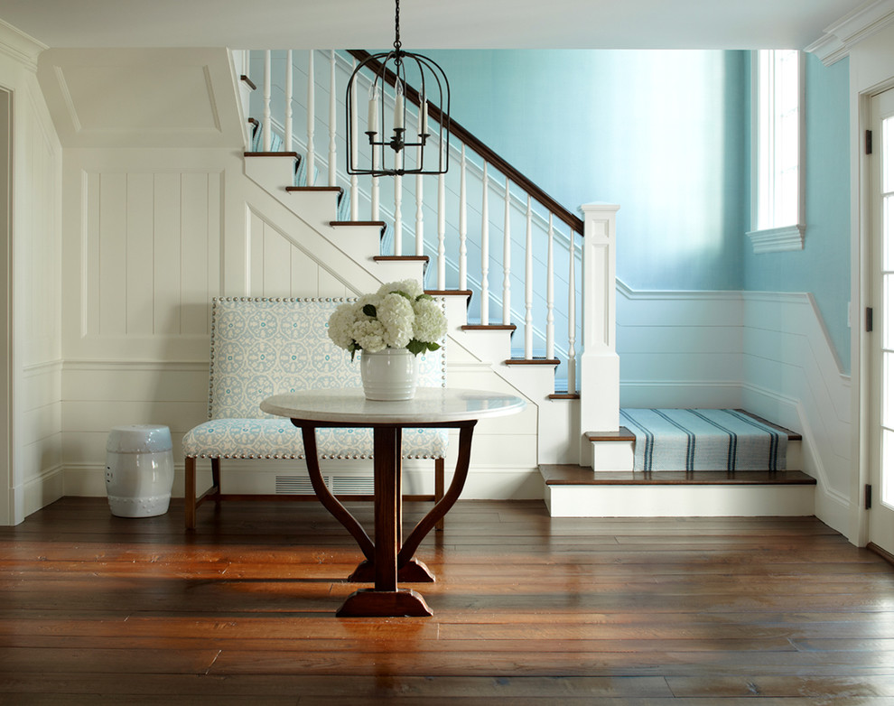 Пример оригинального дизайна: большая п-образная лестница в морском стиле с деревянными перилами, деревянными ступенями и крашенными деревянными подступенками