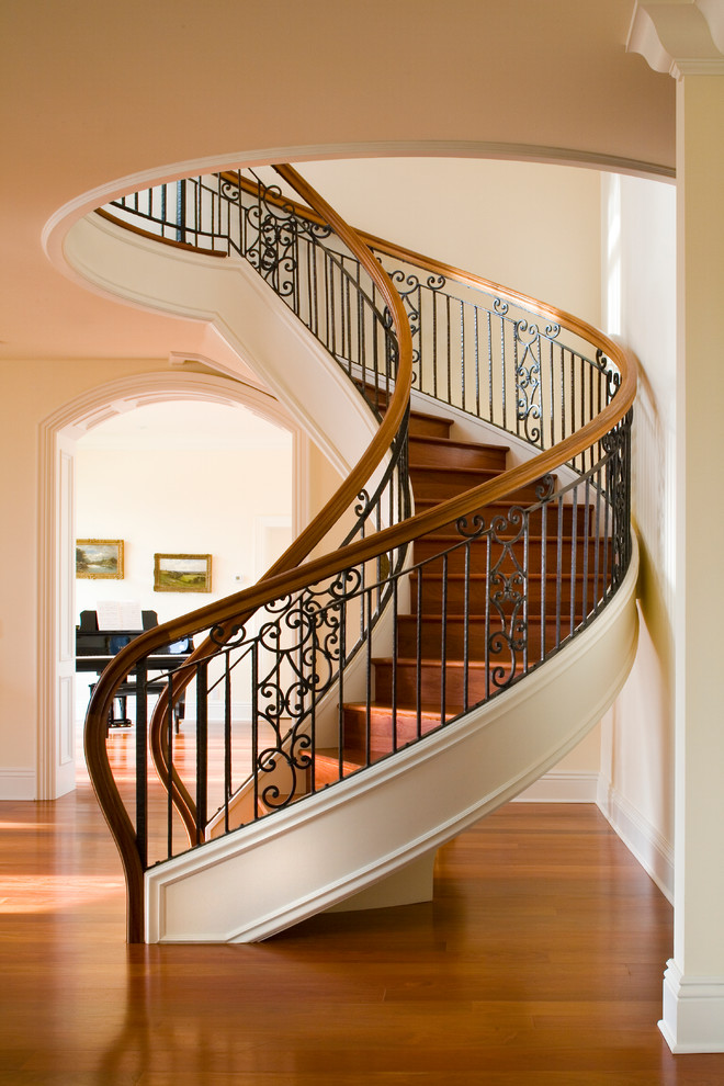 Modelo de escalera curva tradicional con escalones de madera y contrahuellas de madera