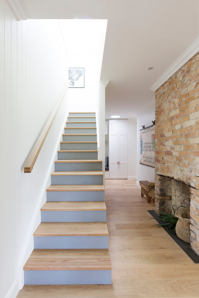 На фото: прямая лестница среднего размера в стиле кантри с деревянными ступенями, крашенными деревянными подступенками и деревянными перилами