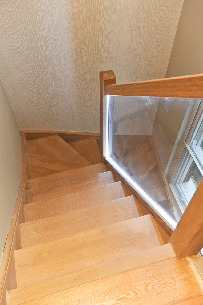 Источник вдохновения для домашнего уюта: изогнутая деревянная лестница среднего размера в стиле модернизм с деревянными ступенями