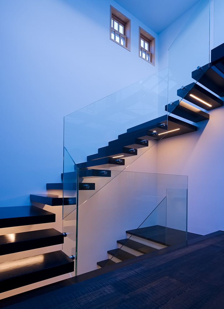 Свежая идея для дизайна: п-образная лестница среднего размера в современном стиле с деревянными ступенями и стеклянными перилами без подступенок - отличное фото интерьера